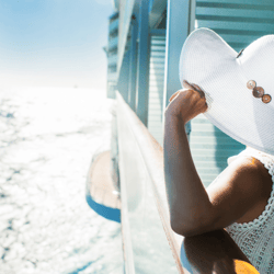 Woman holding hat on cruise ship